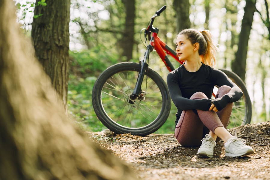 Frau im Wald mit Mountainbike
